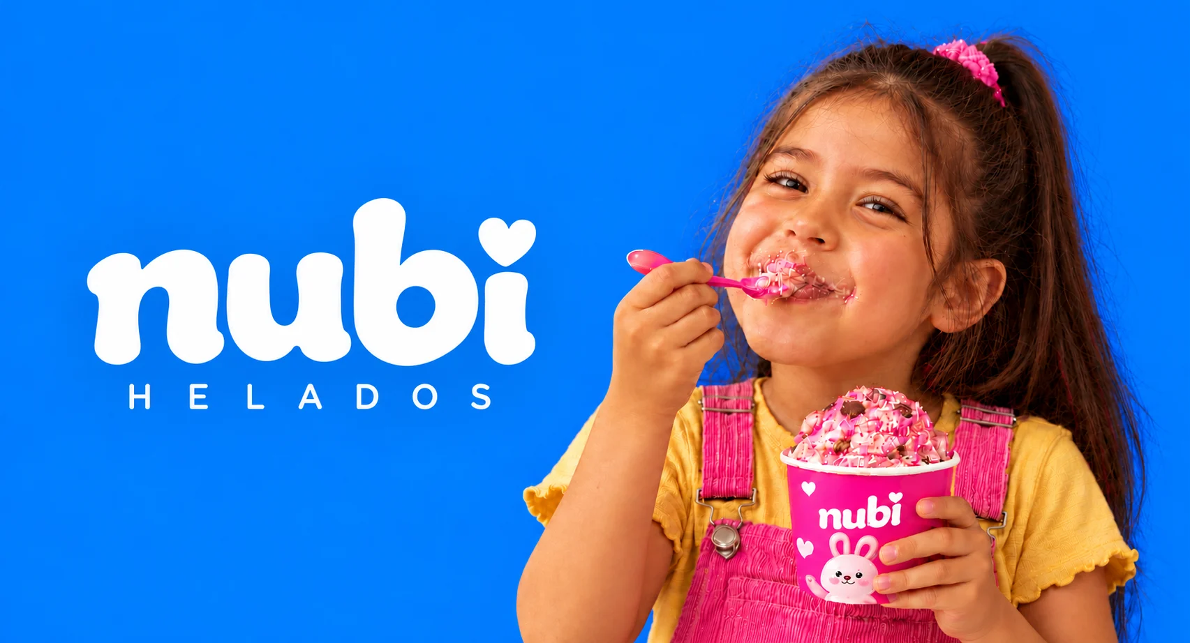 Nubi, helados: banner con el logotipo sobre fondo azul y una niña comiendo helado rosa de una tarrina Nubi con un conejito
